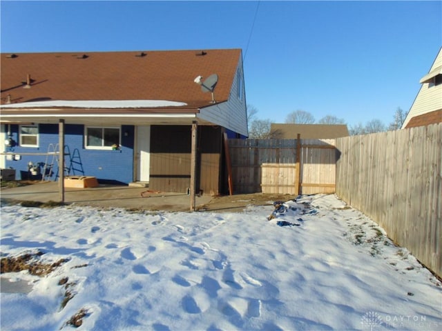 view of snow covered rear of property