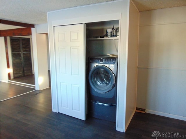 laundry area featuring washer / dryer, dark wood-type flooring, and a textured ceiling