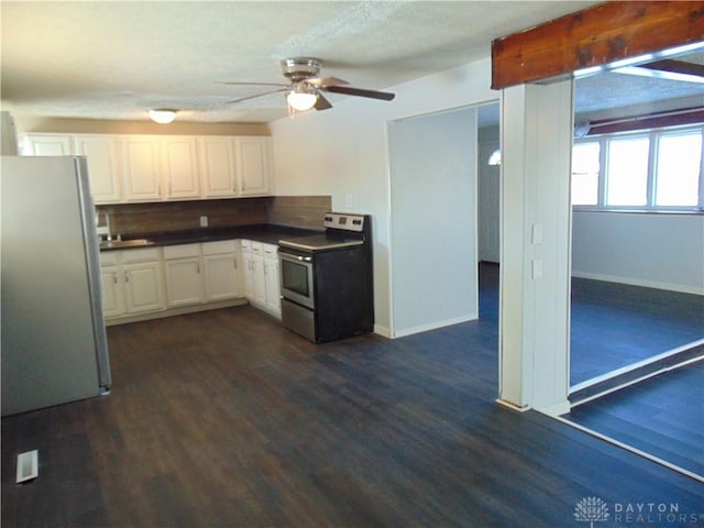 kitchen featuring appliances with stainless steel finishes, white cabinetry, dark hardwood / wood-style flooring, backsplash, and ceiling fan