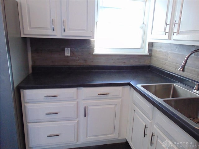 kitchen with white cabinets, tasteful backsplash, and sink