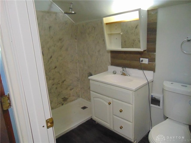 bathroom with walk in shower, vanity, and toilet