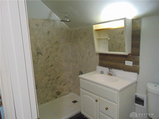 bathroom with toilet, a shower, and vanity