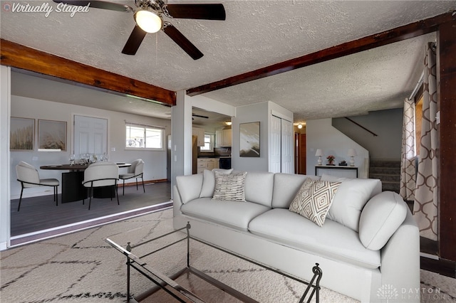5254 Powell Rd, Dayton, OH 45424 - living area featuring stairs, beamed ceiling, a ceiling fan, a textured ceiling, and baseboards