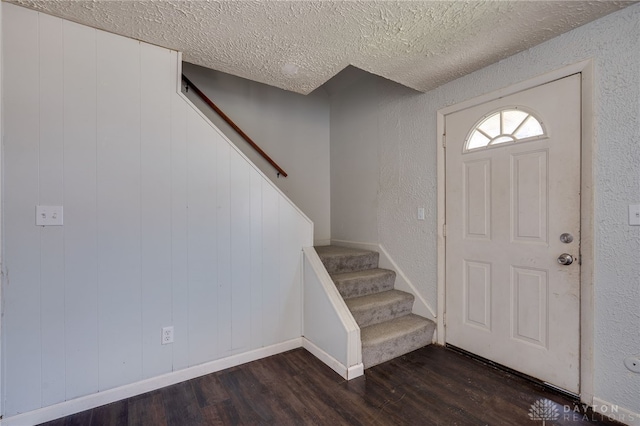 5254 Powell Rd, Dayton, OH 45424 - foyer with dark wood-style floors, a textured ceiling, stairs, baseboards, and a textured wall