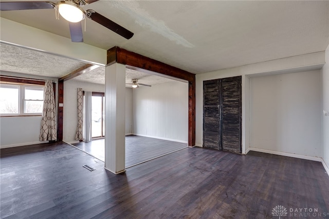 5254 Powell Rd, Dayton, OH 45424 - spare room with a ceiling fan, dark wood-style floors, baseboards, beam ceiling, and a textured ceiling