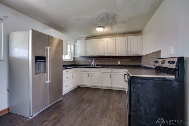 5254 Powell Rd, Dayton, OH 45424 - kitchen with appliances with stainless steel finishes, dark wood finished floors, a sink, dark countertops, and a textured ceiling