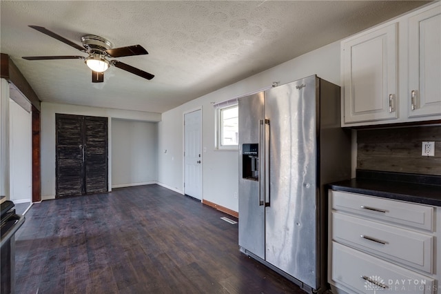 5254 Powell Rd, Dayton, OH 45424 - kitchen with stainless steel fridge, dark countertops, dark wood-style flooring, ceiling fan, and white cabinetry