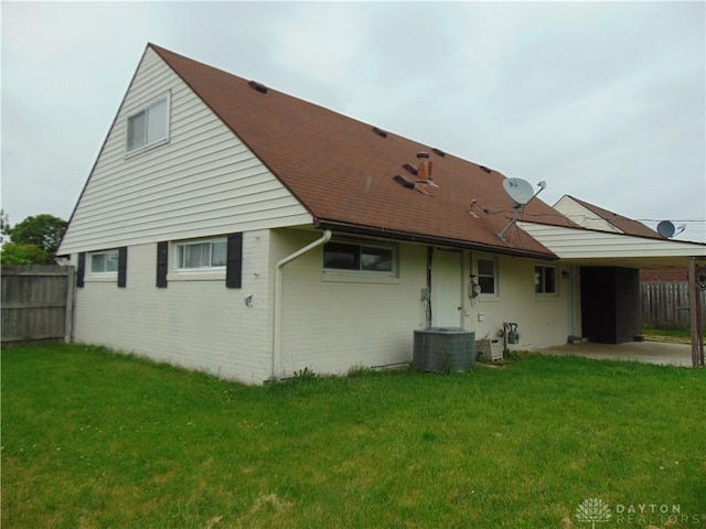 5254 Powell Rd, Dayton, OH 45424 - back of property featuring a carport, central air condition unit, a patio, and a shingled roof