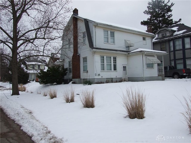 view of snow covered rear of property