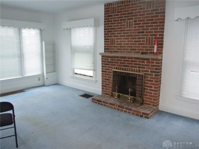 unfurnished living room with carpet, a healthy amount of sunlight, and a fireplace