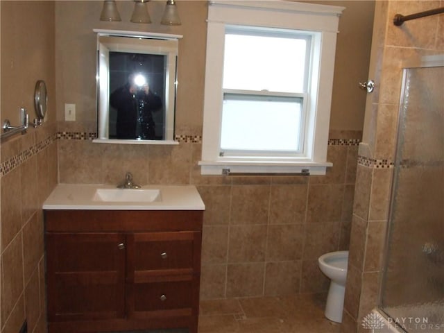 bathroom with a shower with door, tile walls, toilet, and vanity