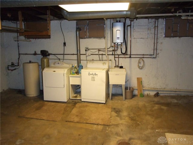 basement with washing machine and dryer, sink, and water heater