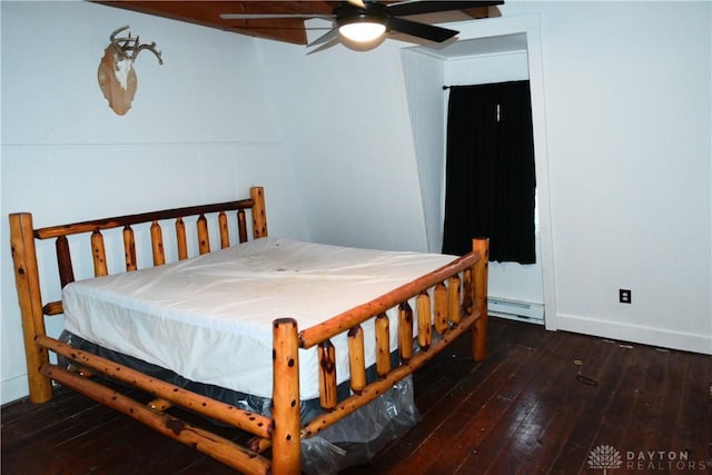 bedroom with ceiling fan, dark wood-type flooring, and a baseboard radiator