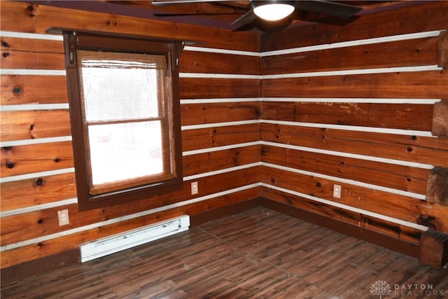 spare room with ceiling fan, a baseboard heating unit, and wooden walls