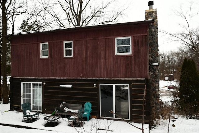 snow covered house featuring an outdoor fire pit