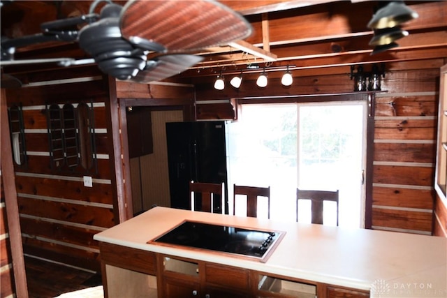 kitchen featuring wood walls and black appliances