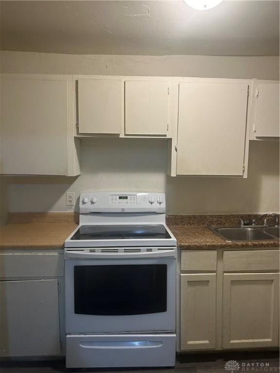 kitchen with white cabinetry, sink, and white range with electric stovetop