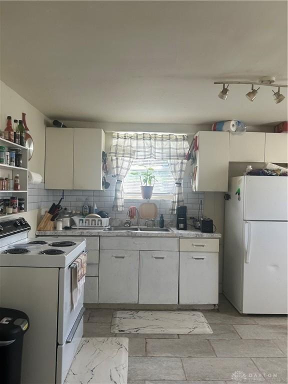 kitchen with sink, white appliances, backsplash, and white cabinets