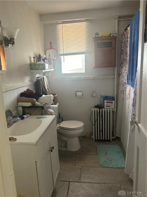 bathroom featuring toilet, radiator heating unit, and vanity