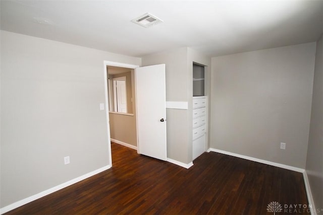 unfurnished bedroom featuring dark hardwood / wood-style flooring