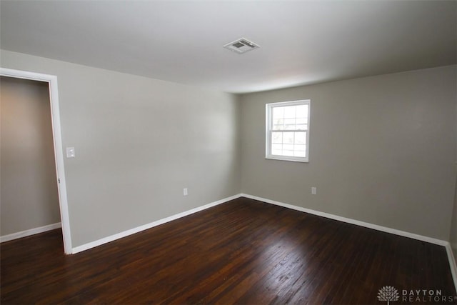 spare room featuring dark wood-type flooring