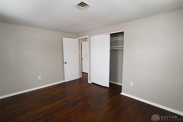 unfurnished bedroom featuring a closet and dark hardwood / wood-style flooring