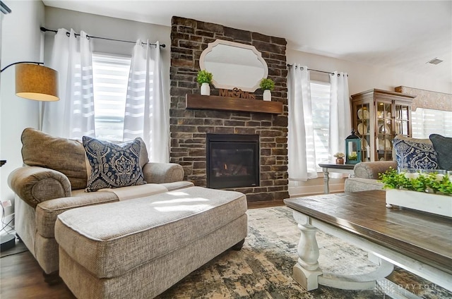 living room with dark wood-type flooring and a large fireplace