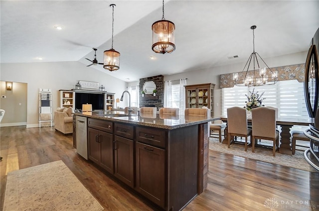 kitchen featuring pendant lighting, a notable chandelier, dark brown cabinets, and dark stone counters