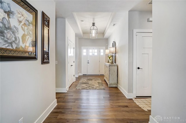 interior space with dark hardwood / wood-style flooring and a tray ceiling