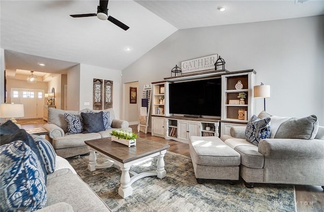 living room with wood-type flooring, ceiling fan, and vaulted ceiling