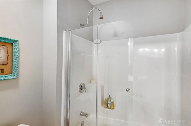 bathroom featuring shower / bath combination with glass door and toilet