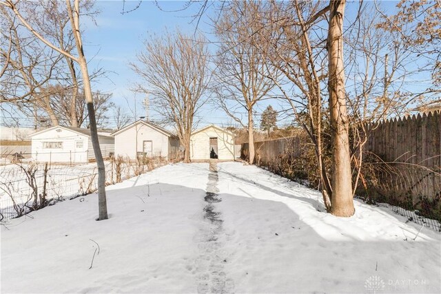 yard covered in snow featuring an outbuilding