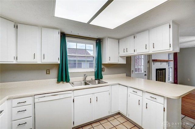 kitchen with sink, white cabinets, dishwasher, and kitchen peninsula