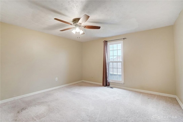 carpeted spare room featuring ceiling fan and a textured ceiling