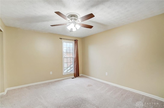 carpeted empty room with ceiling fan and a textured ceiling