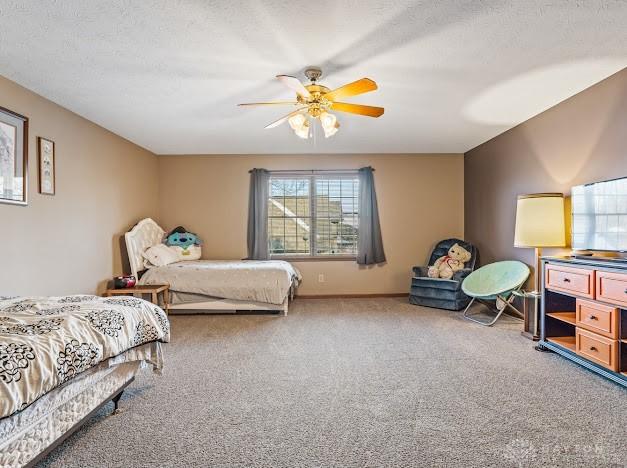 bedroom featuring ceiling fan, a textured ceiling, and carpet floors