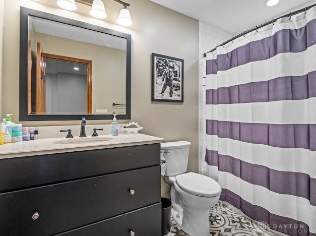 bathroom with toilet, a shower with curtain, and vanity