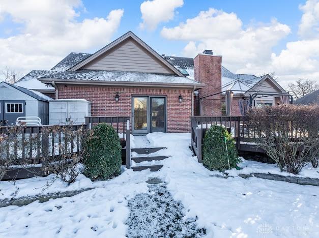 snow covered house with a deck