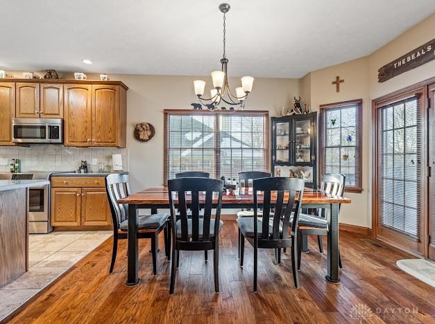 dining space featuring light hardwood / wood-style flooring and an inviting chandelier