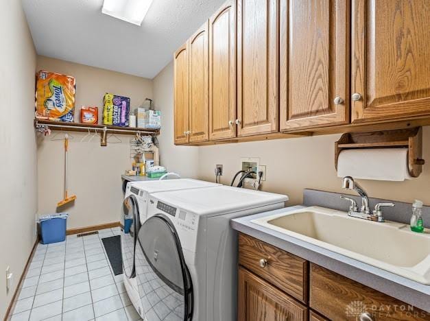 clothes washing area featuring cabinets, separate washer and dryer, light tile patterned floors, and sink