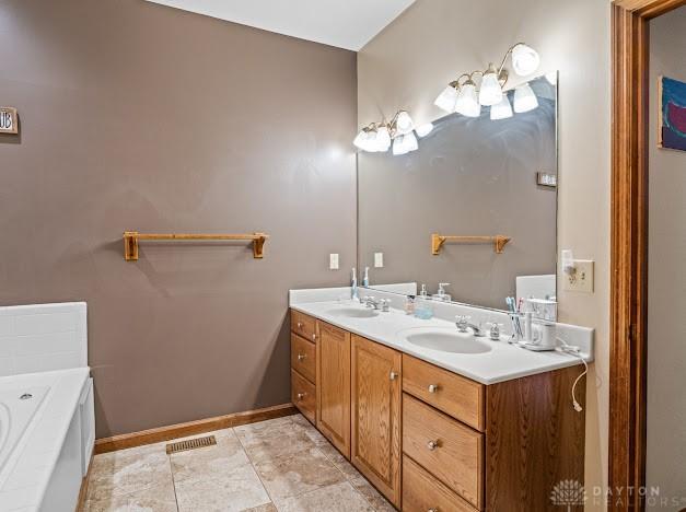 bathroom with vanity and a bath