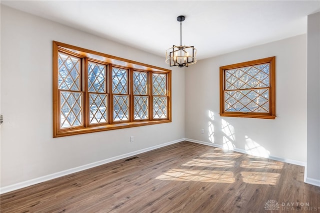 unfurnished room with dark hardwood / wood-style floors and a notable chandelier