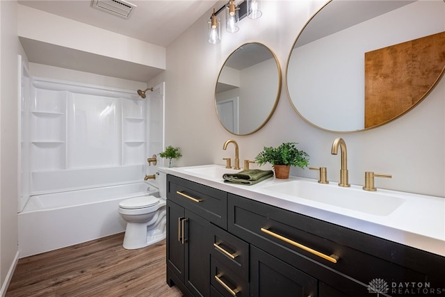 full bathroom with toilet, bathtub / shower combination, vanity, and hardwood / wood-style floors