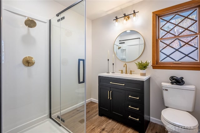 bathroom featuring a shower with shower door, wood-type flooring, toilet, and vanity