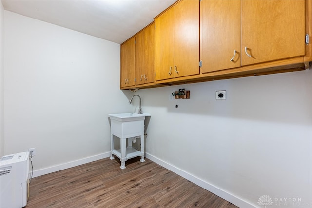 laundry room featuring dark hardwood / wood-style flooring, hookup for an electric dryer, and cabinets