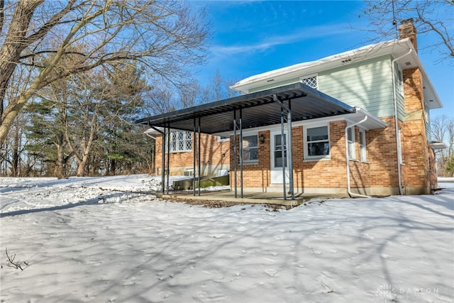 view of snow covered back of property