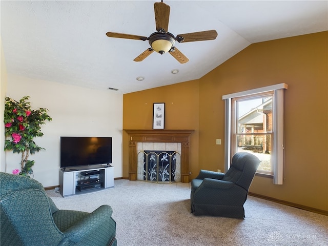 carpeted living room with vaulted ceiling, ceiling fan, and a fireplace