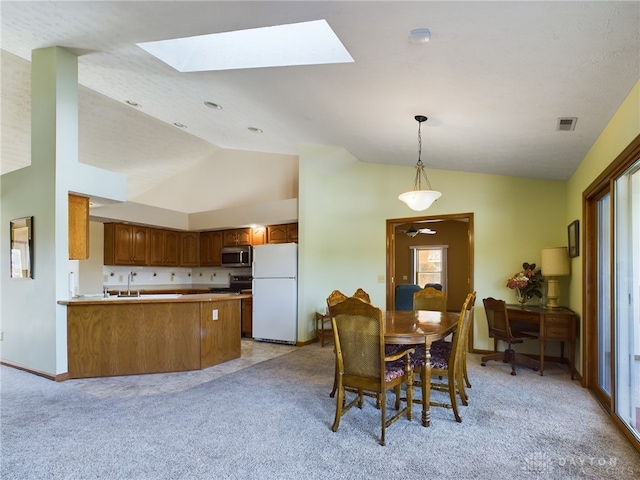 dining space with lofted ceiling, light carpet, plenty of natural light, and sink