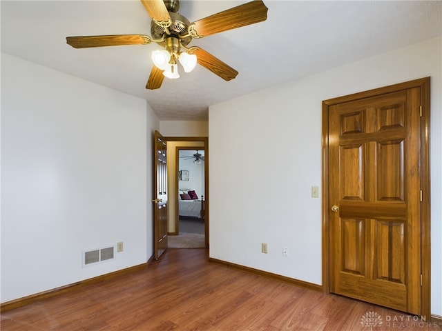 empty room featuring ceiling fan and hardwood / wood-style floors