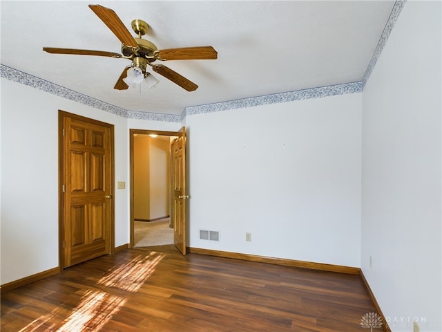 empty room featuring ceiling fan and dark hardwood / wood-style floors